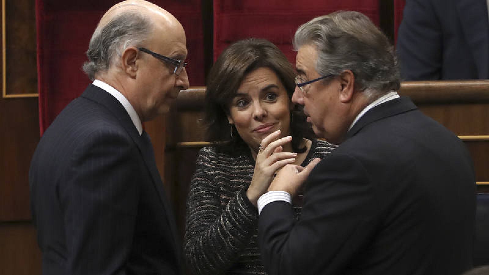 La vicepresidenta del Gobierno, Soraya Sáenz de Santamaría, junto con el ministro de Hacienda, Cristóbal Montoro y el de Interior, Juan Ignacio Zoido
