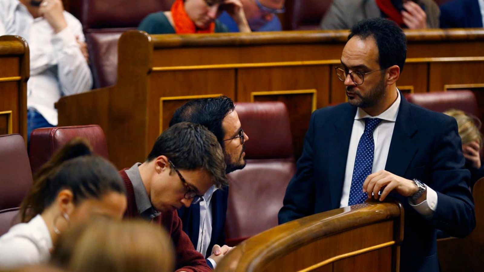 El portavoz del PSOE en el Congreso, Antonio Hernando (d), conversa con el diputado de Unidos Podemos, Alberto Garzón, durante su intervención esta tarde en el pleno de la Cámara baja.