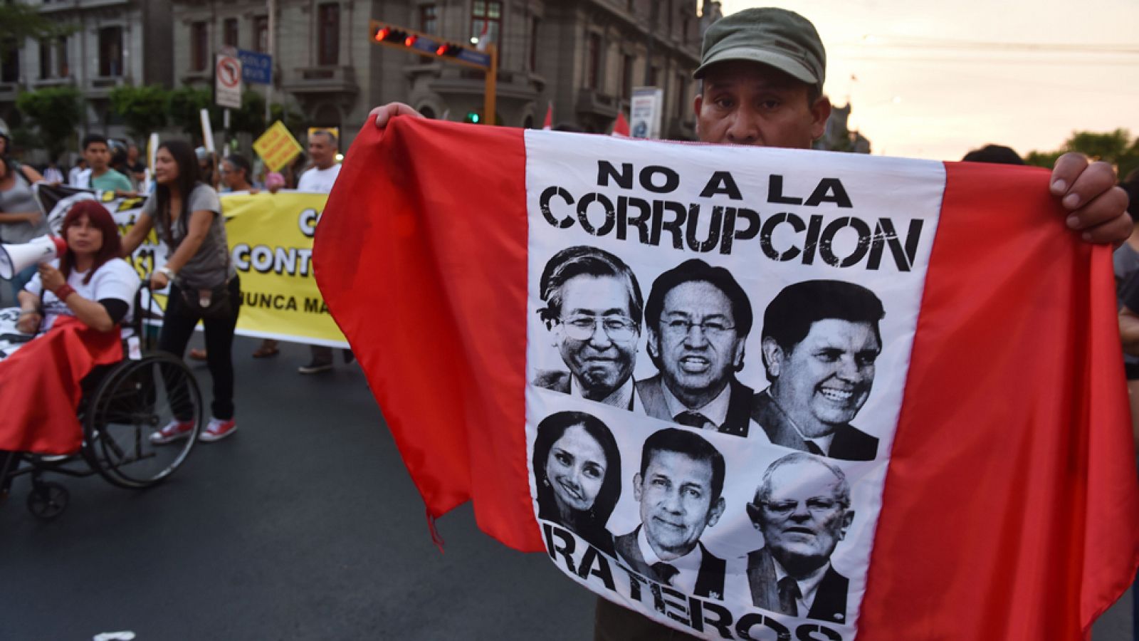 Un hombre protesta con una bandera que muestra los rostros de Fujimori, Toledo, Alan García, Ollanta Humala y Kuczynski, en Lima, Perú