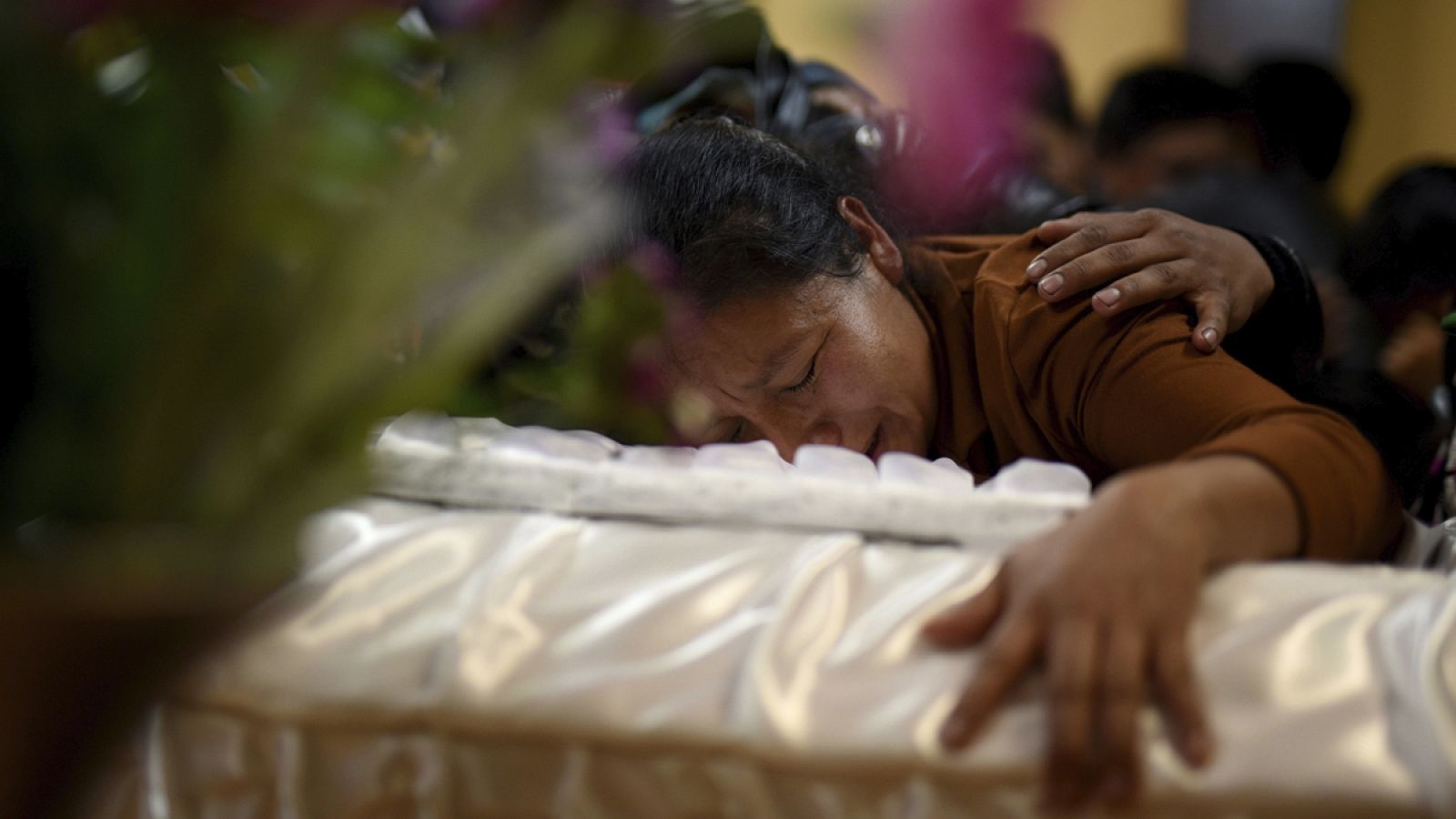 Una mujer llora sobre el féretro de su hija, una de las 35 niñas que murieron en el incendio del centro de menores de Guatemala