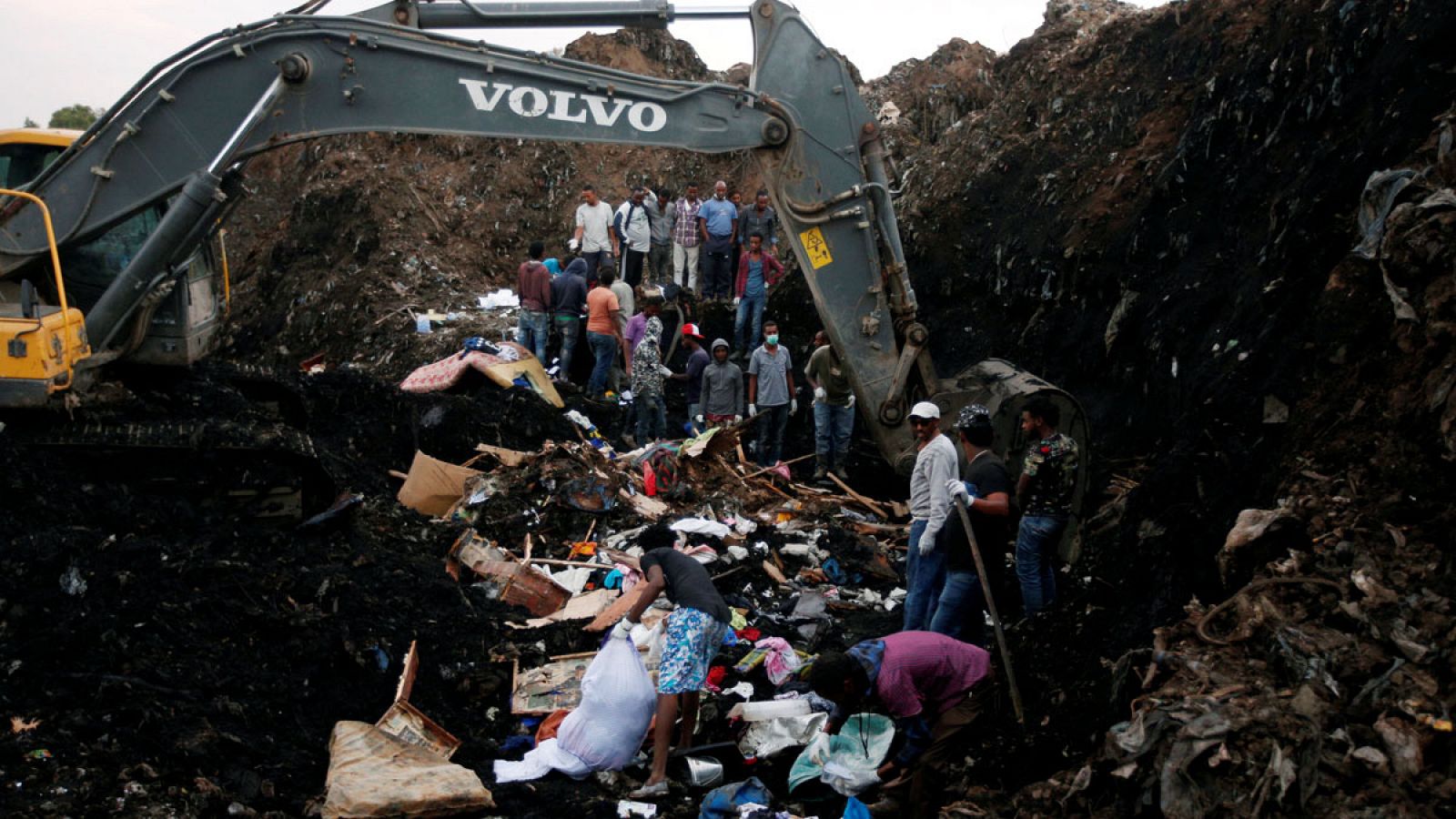 Excavadoras, miembros de los cuerpos de rescate y vecinos buscan supervivientes en el vertedero de Repi, en Adís Abeba (Etiopía) tras un corrimiento de tierra.