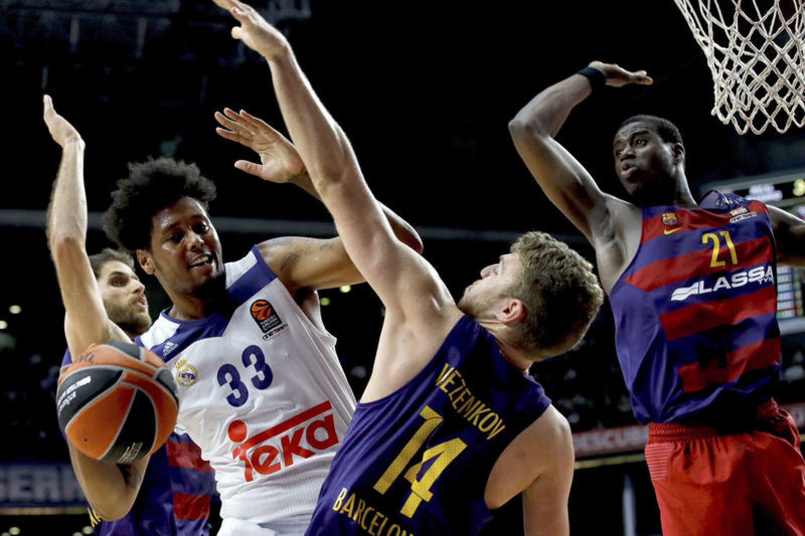 El madridista Thompkins lucha por un rebote con jugadores del Barça