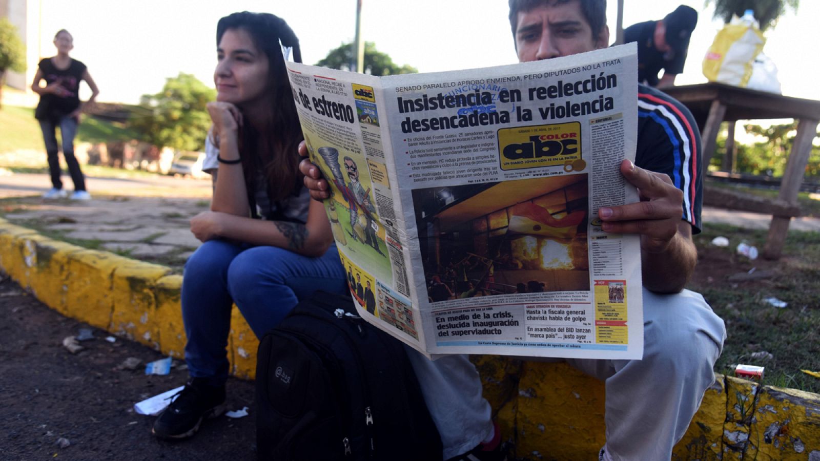Un hombre lee un periódico que recoge la violencia desatada tras la aprobación de un decreto que permite la reelección del presidente