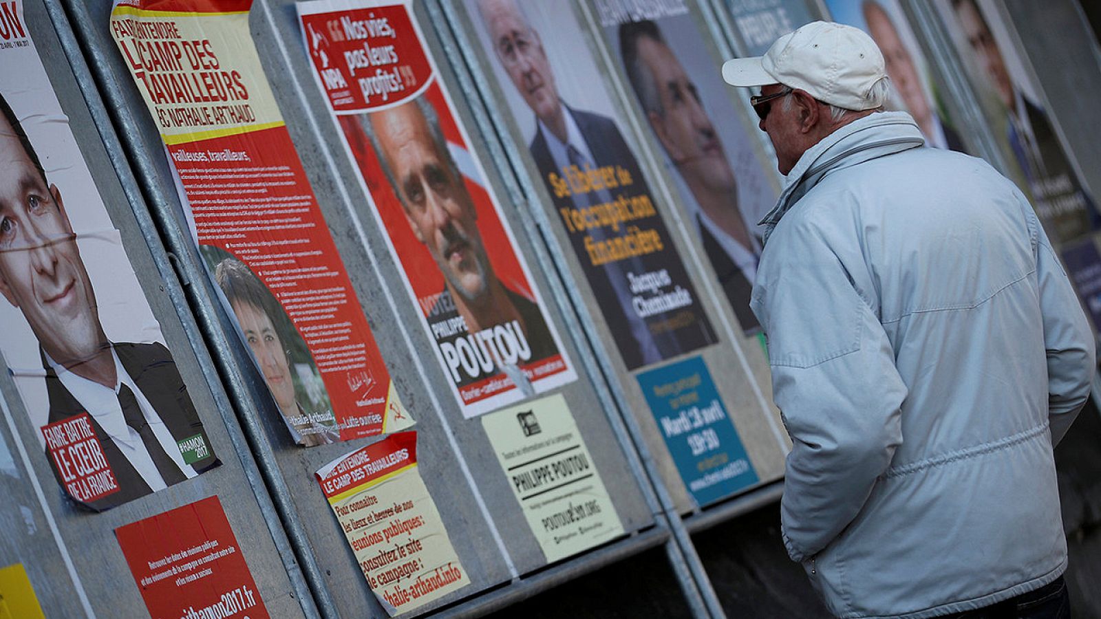 Un hombre pasa junto a carteles electorales en Enghien-les-Bains, cerca de París, Francia