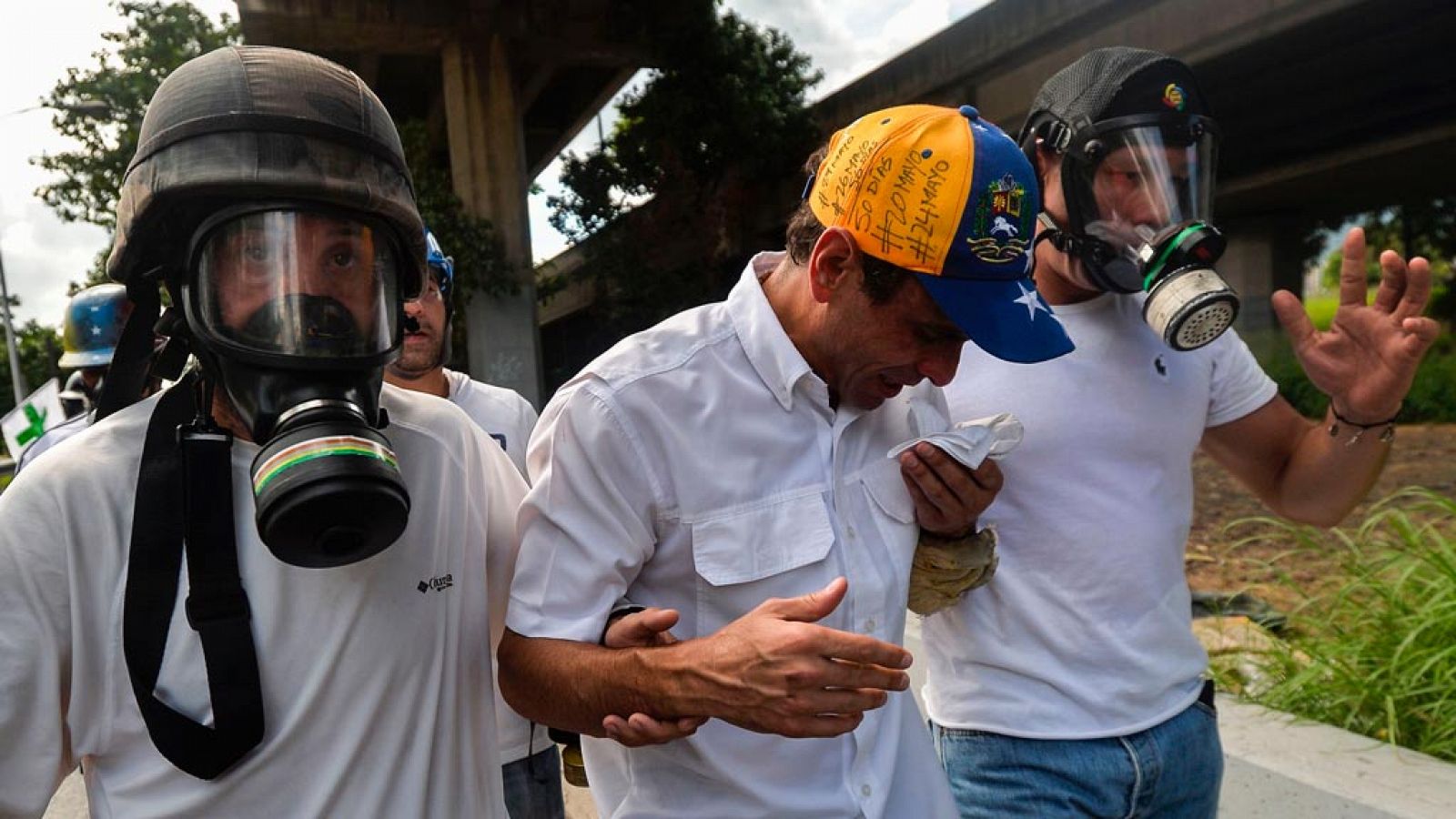 El líder opositor venezolano Henrique Capriles (centro), he asistido tras sufrir los efectos del gas lacrimógeno lanzado durante la marca antichavista de este lunes