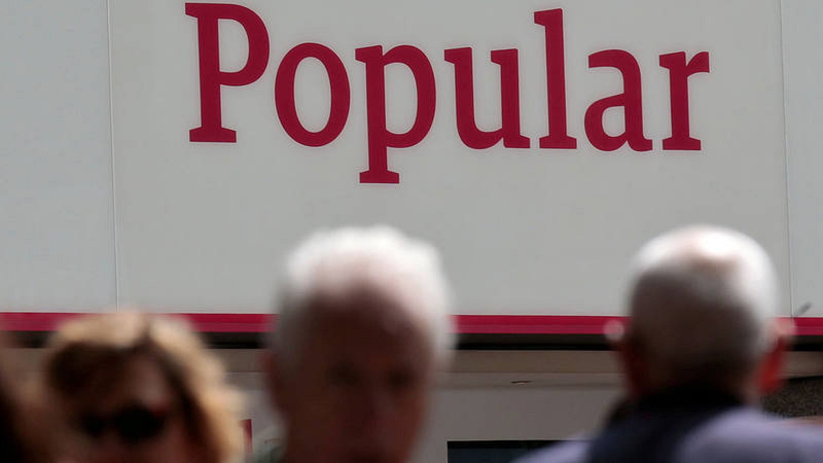 Gente delante de una sucursal del Banco Popular