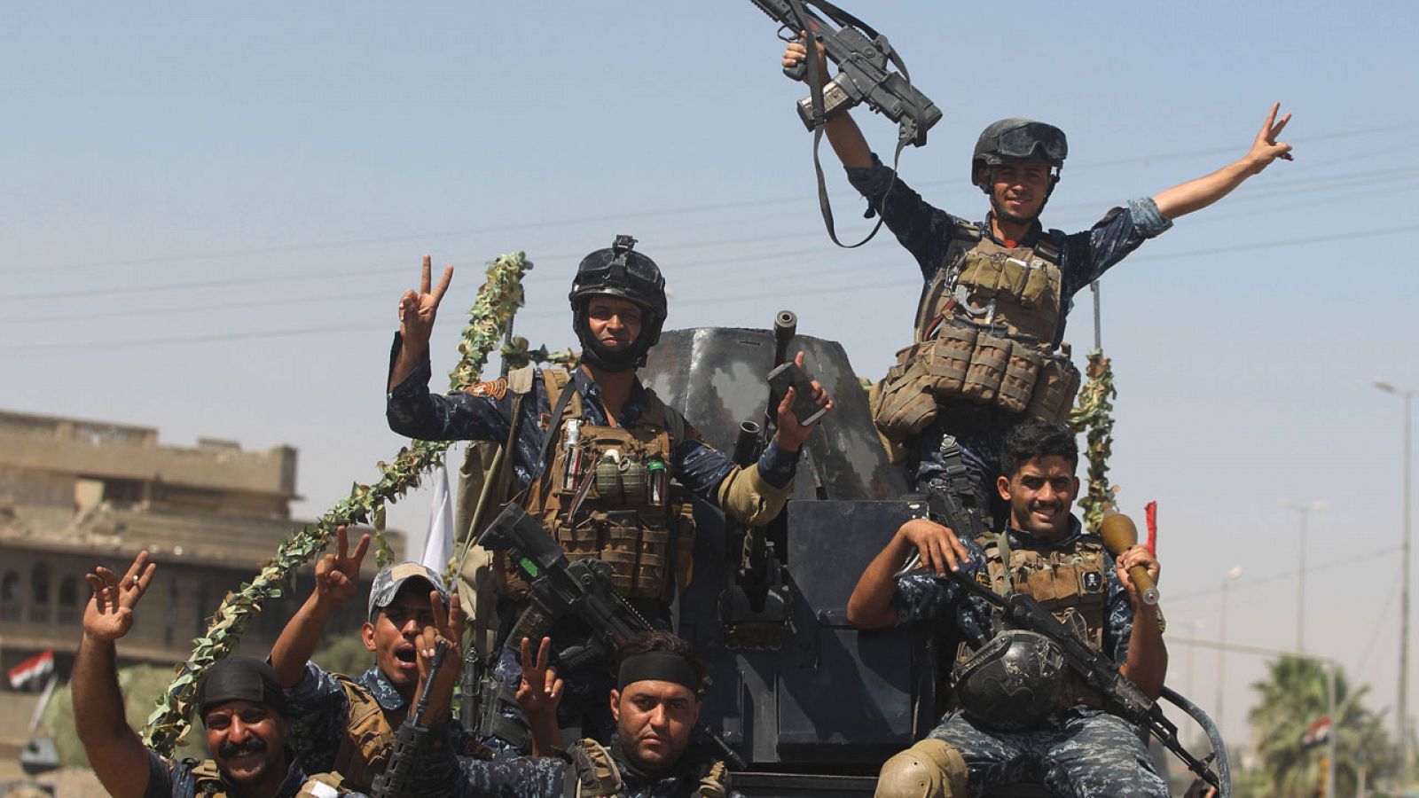 Miembros de la policía federal iraqui hacen el gesto de la victoria en la Ciudad Vieja de Mosul.
