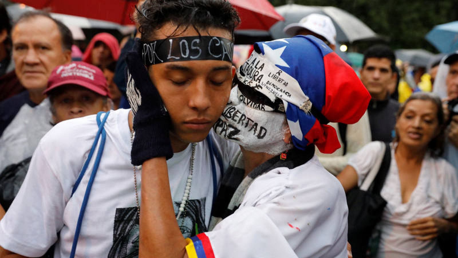 Dos opositores venezolanos se consuelan en un homenaje a las víctimas de las protestas en Venezuela.  