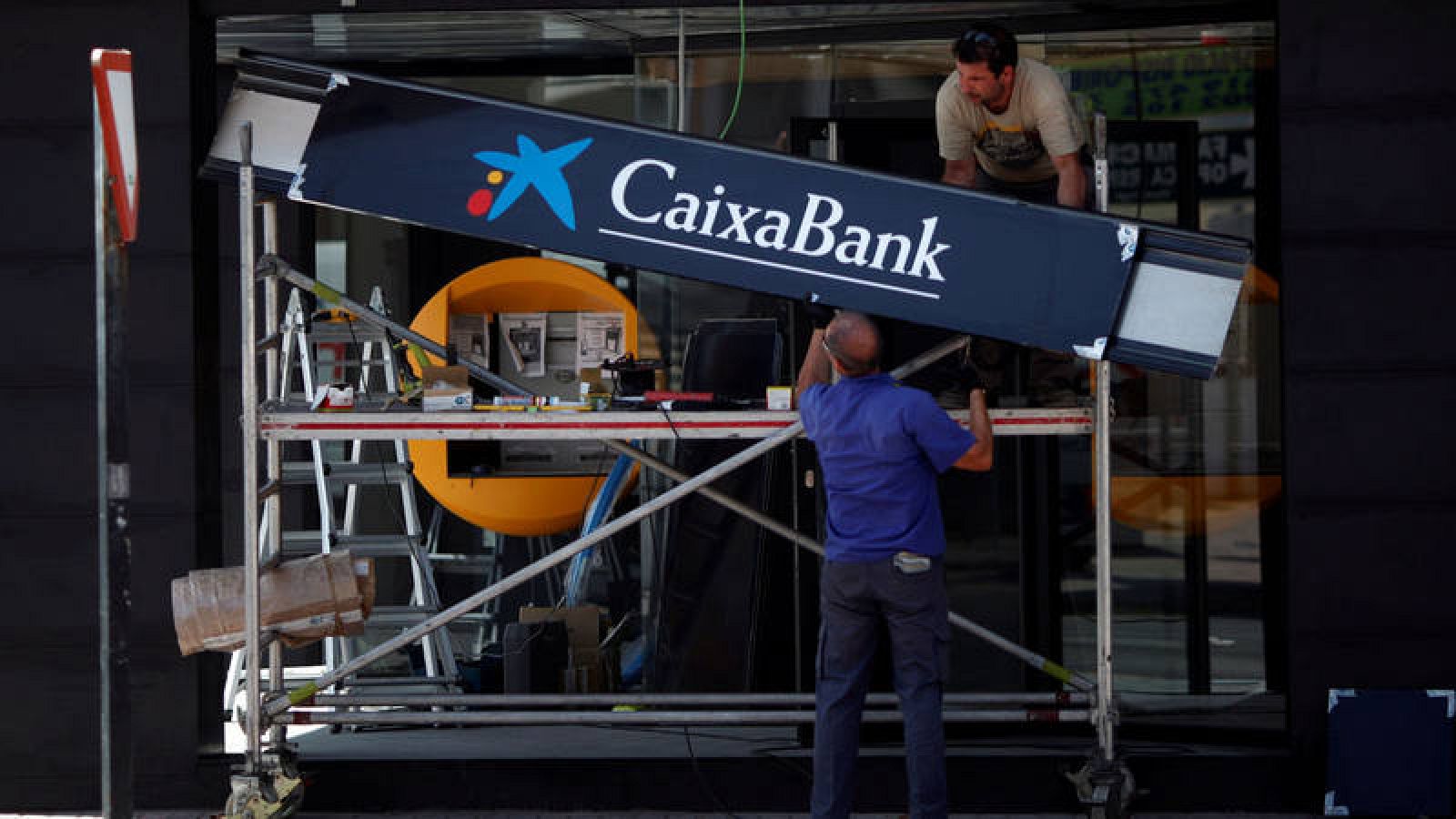 Imagen de archivo de unos trabajadores en la obra para la apertura de una sucursal de CaixaBank en Ronda. 