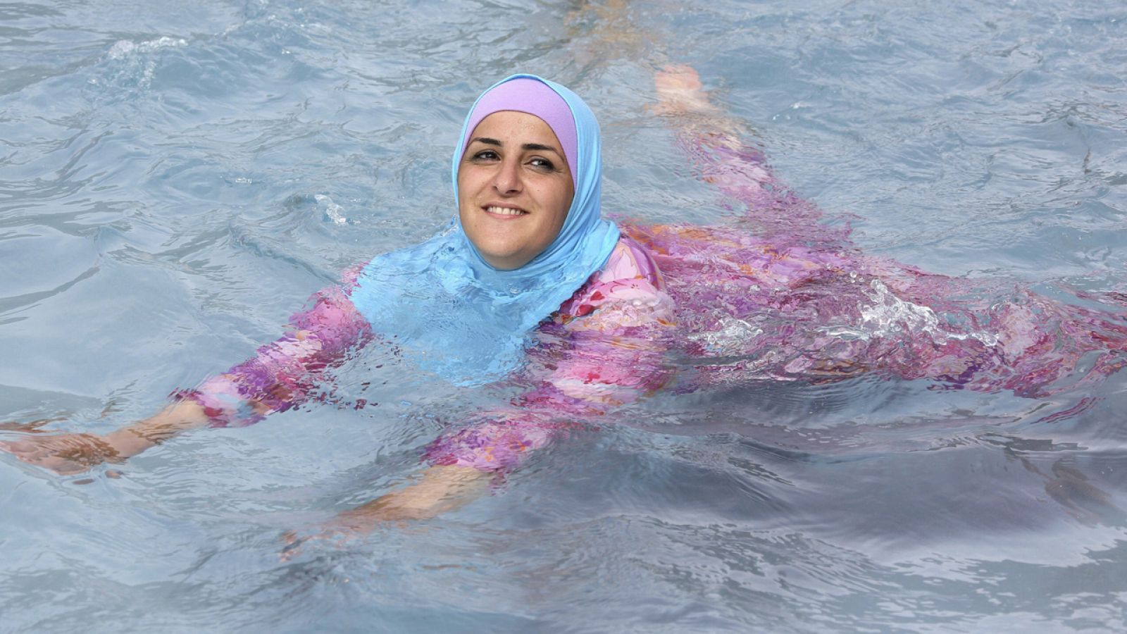 Foto Mujer con gorro de baño azul en la piscina – Imagen Agua