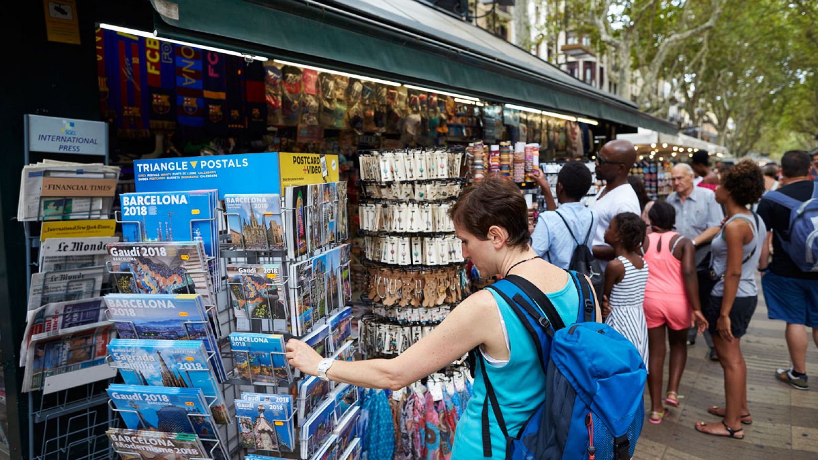 Turistas compran souvenirs en los quioscos de La Rambla de Barcelona