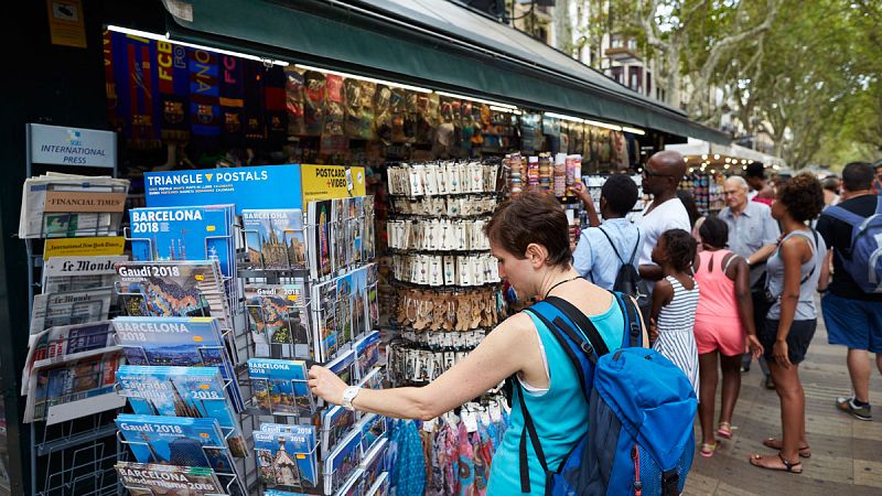 Turistas compran souvenirs en los quioscos de La Rambla de Barcelona