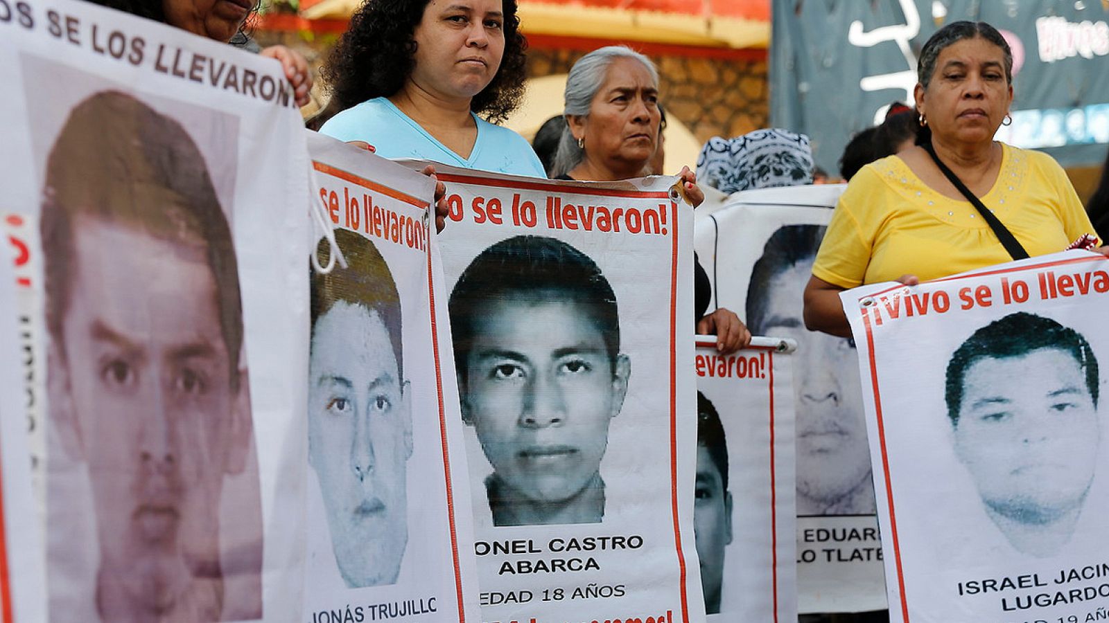 Estudiantes y padres de los 43 jóvenes desaparecidos de Ayotzinapa muestran carteles con los retratos de sus hijos