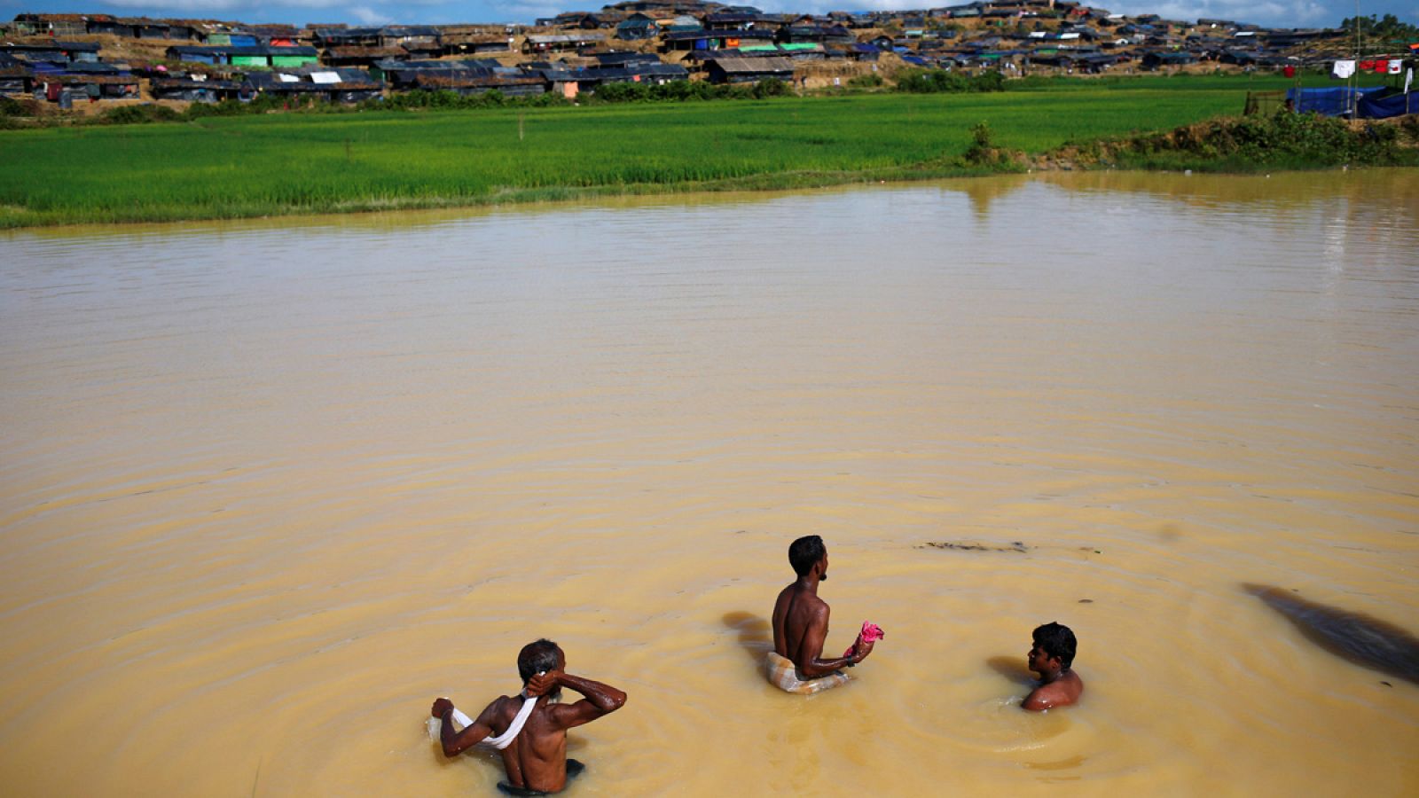 Tres rohinyás se bañan en una laguna cerca de su campamento en Cox's Bazar, Bangladesh