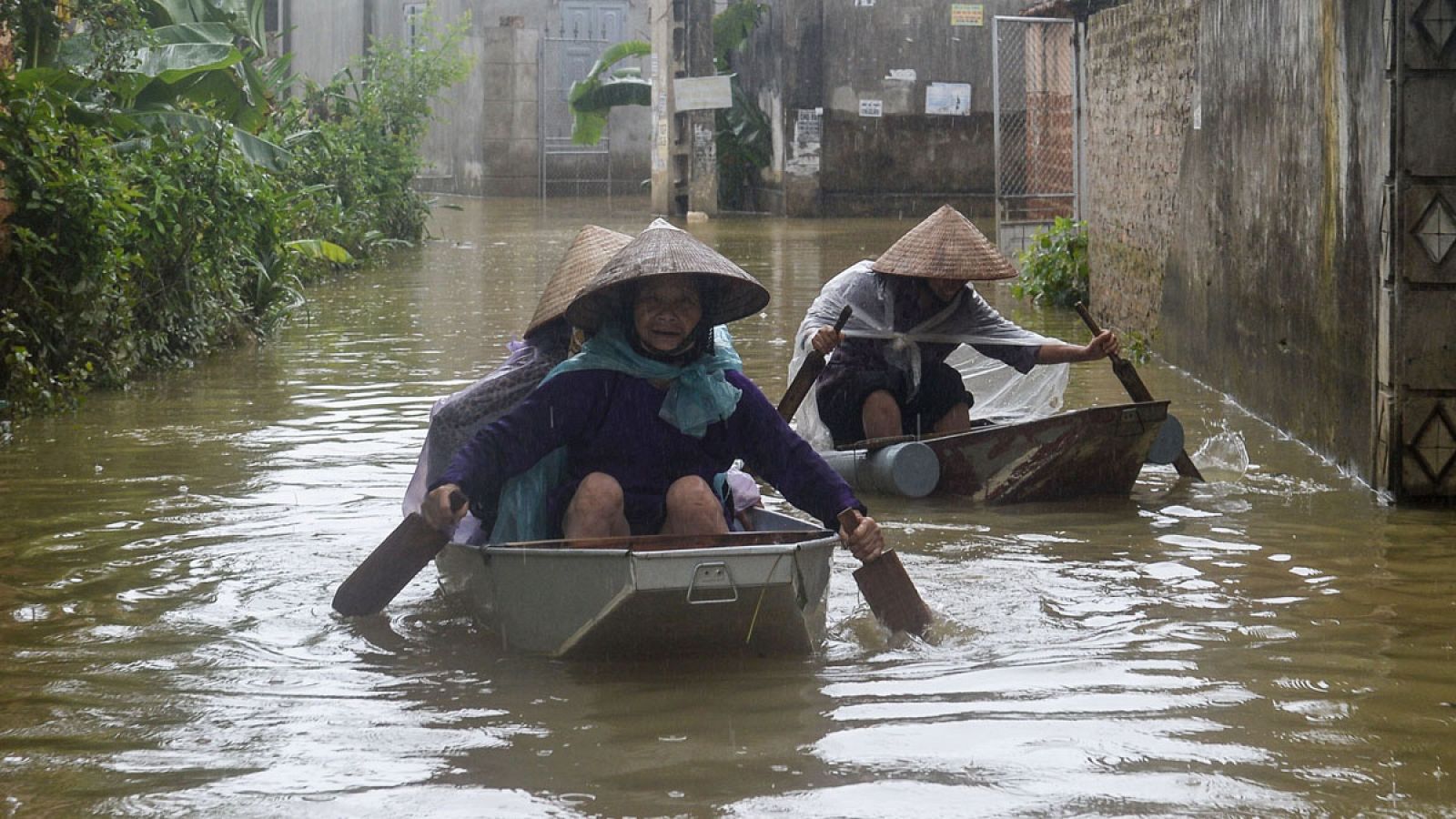 Dos mujeres navegan por las calles inundadas en Hanoi
