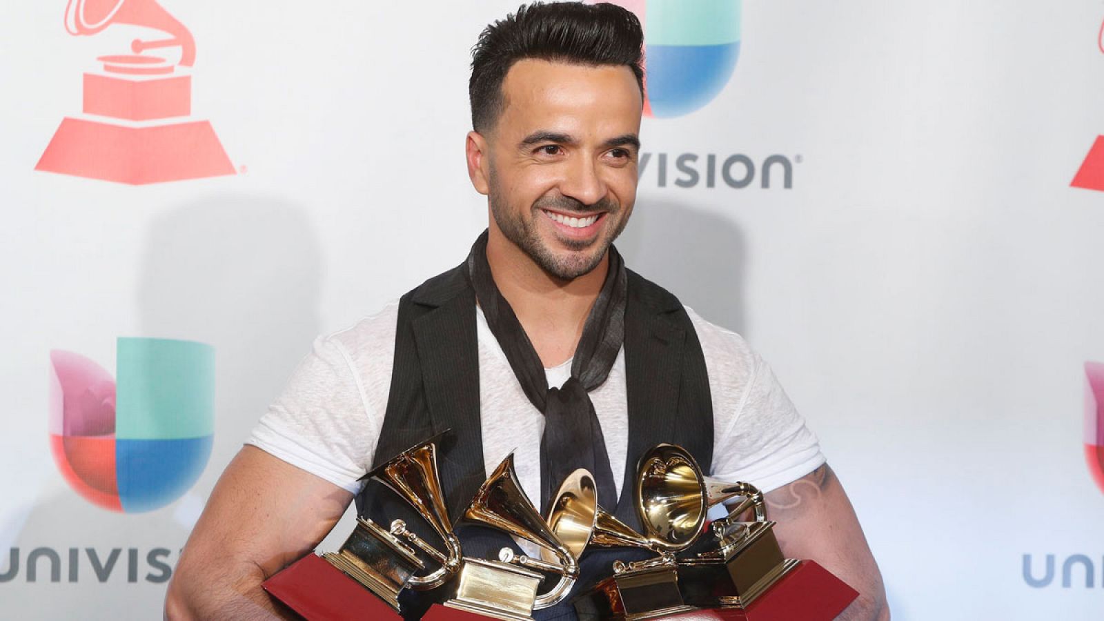 El cantante puertorriqueño Luis Fonsi sujeta los cuatro premios que ha logrado el tema "Despacito" en la 18 edición de los Grammy Latino.