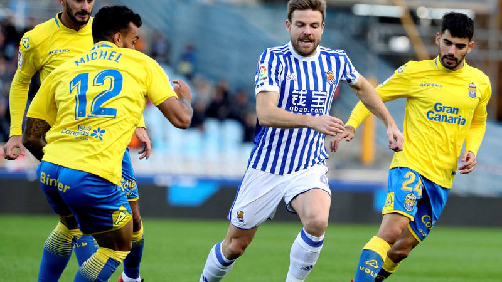Asier Illarramendi (c) disputa un balón con los jugadores de Las Palmas Míchel Macedo (i) y 'Tana' (d).