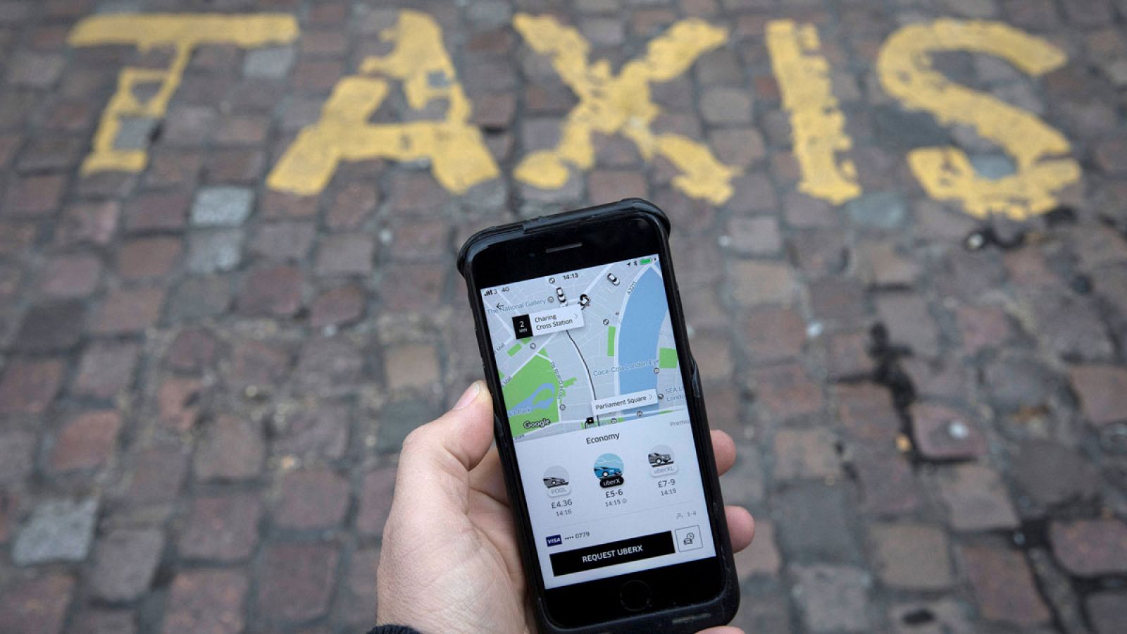 Un móvil con la aplicación de Uber abierta en una parada de taxis