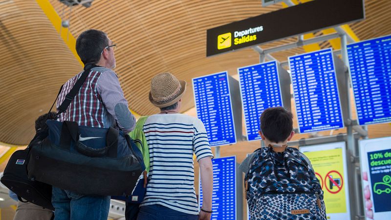 Unos viajeros comprueban el estado de sus vuelos en la T4
