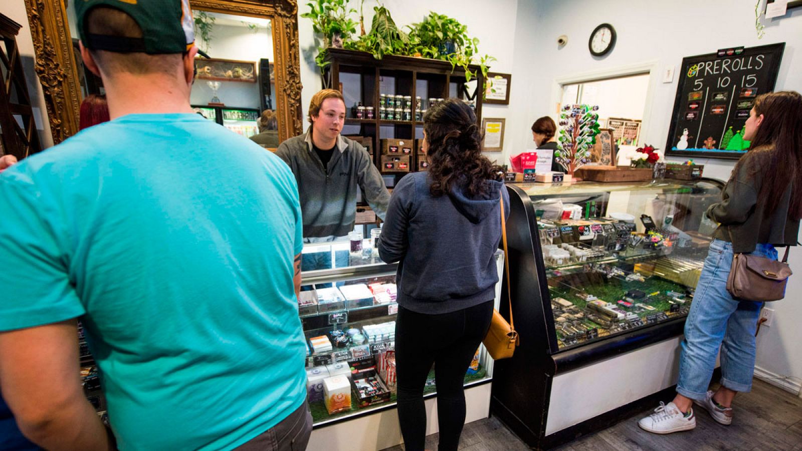 Un dependiente ayuda a los clientes mientras otros esperan su turno en el dispensario de marihuana medicinal de Higher Path en el área de San Fernando Valley en Los Ángeles, California.