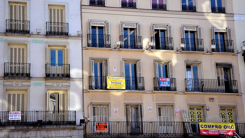 Fachada de un edificio de la capital con diferentes carteles de alquiler y venta.