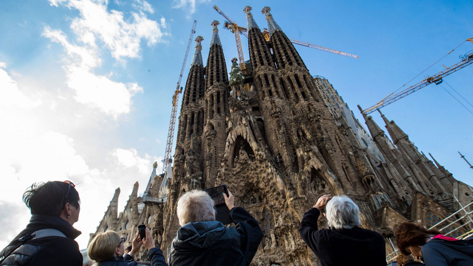 Un grupo de turistas fotografía la Sagrada Familia en Barcelona