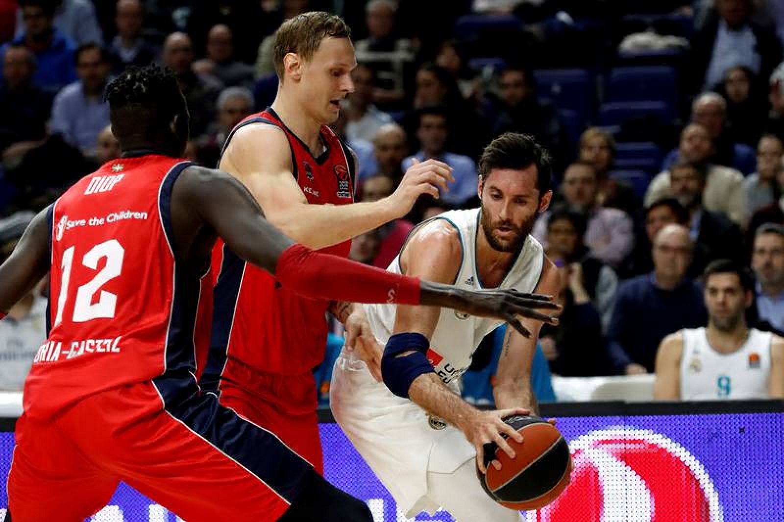 El alero del Real Madrid, Rudy Fernández (d), intenta escaparse de los jugadores del Baskonia, el alero letón Janis Timma (c) y el pívot senegalés Ilimane Diop (i).