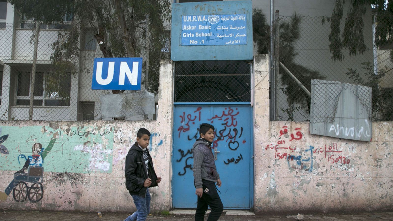 Dos niños palestinos caminan en el exterior de una escuela de la ONU en Cisjordania