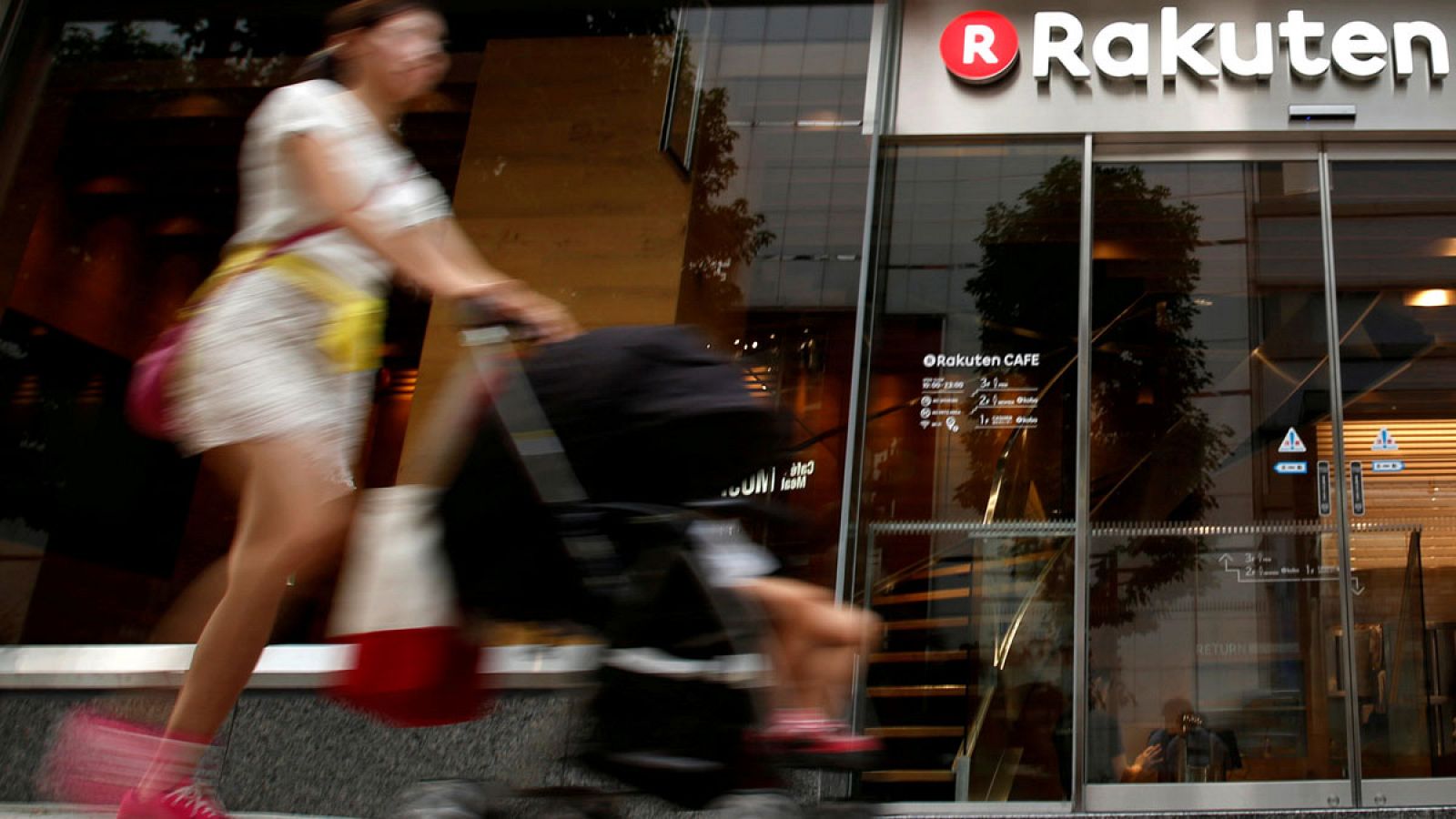 Una transeúnte pasa delante de una cafetería de Rakuten en el distrito comercial de Tokio