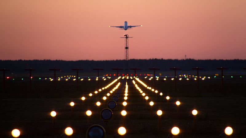 Imagen de archivo de un avión despegando al atardecer.