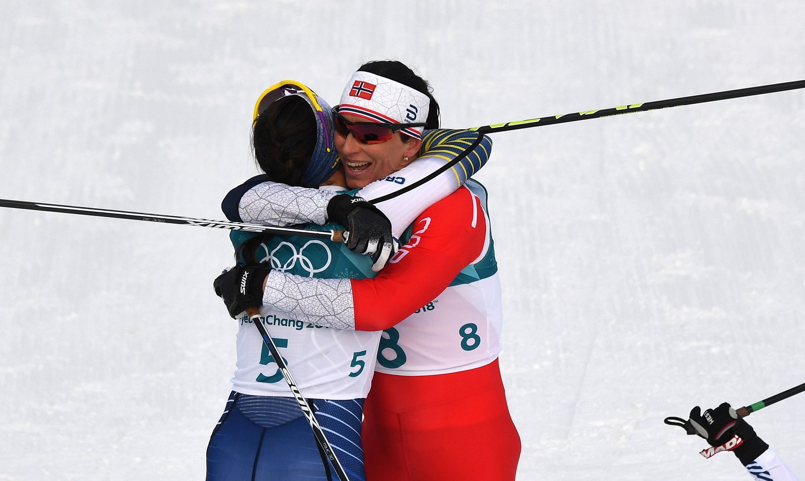 Bjoergen (dcha) celebra su medalla junto a la ganadora, Kalla.