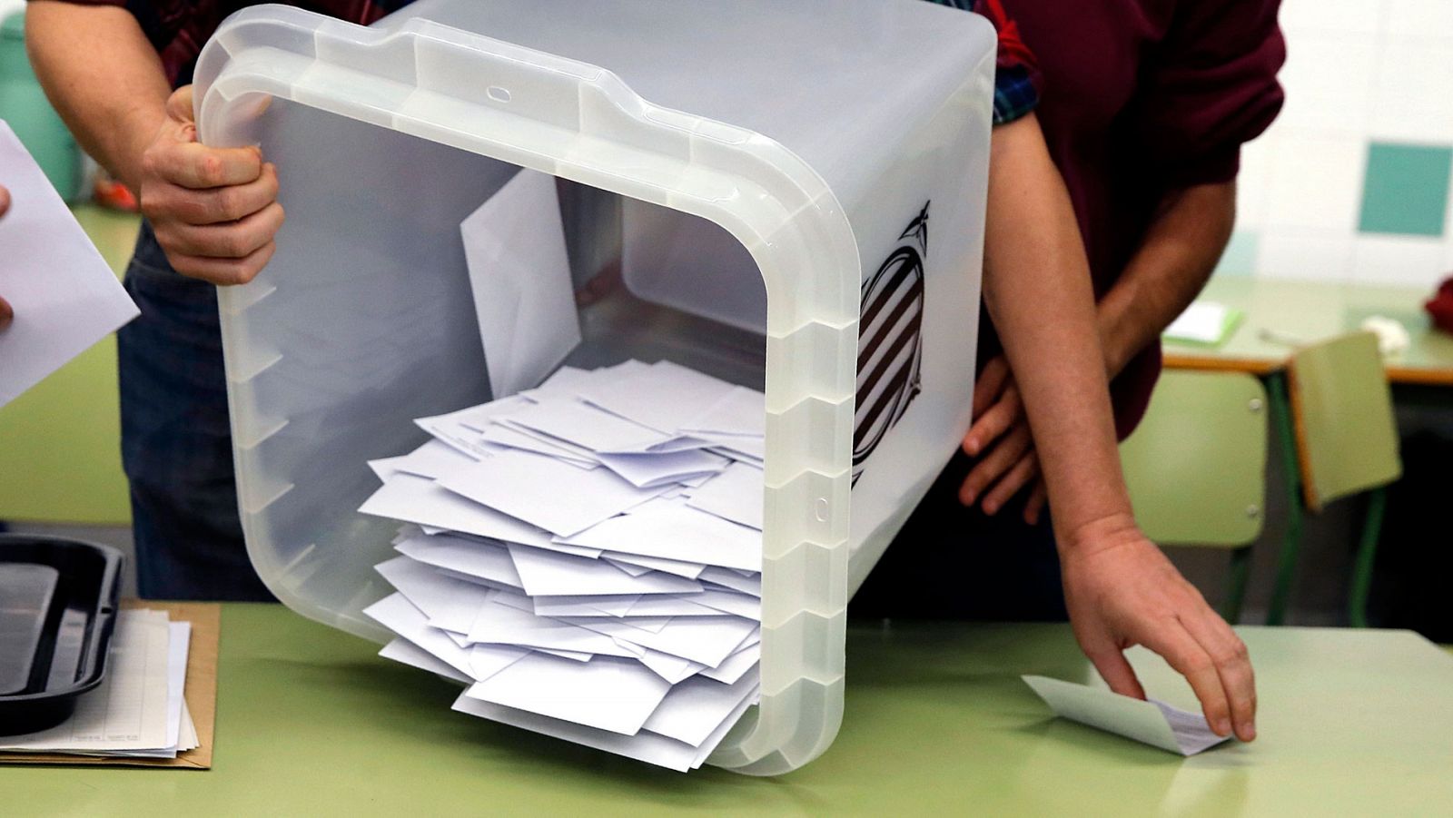 Un miembro de la mesa vuelca una urna del 1-O para comenzar el recuento del referéndum ilegal