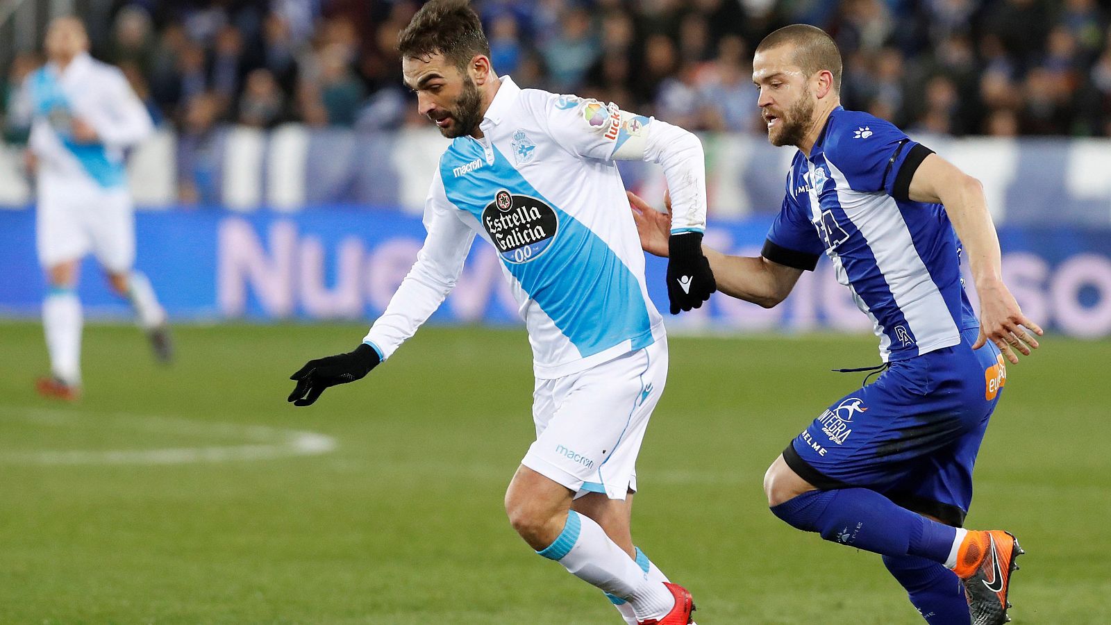 Adrián (i), del Deportivo, trata de marcharse de la marca de Laguardia, del Alavés (d).