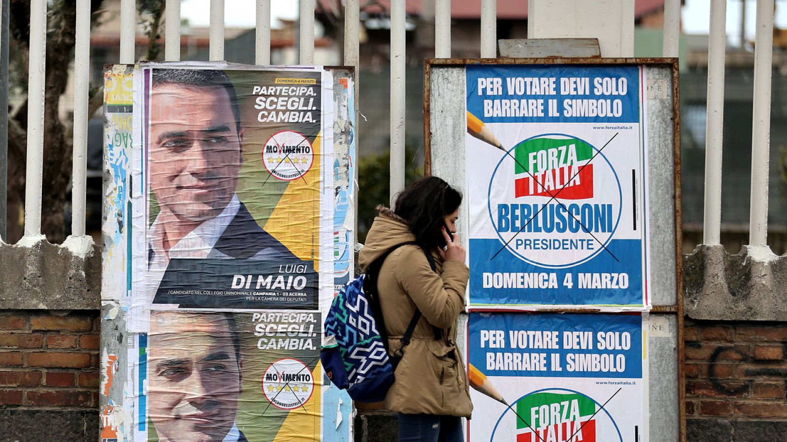 Una mujer pasa ante varios carteles electorales en Roma