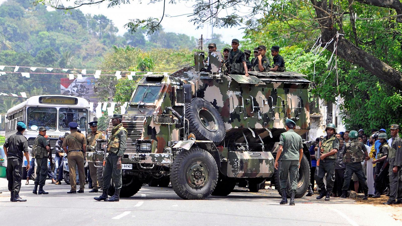 Sri Lanka's army soldiers stand guard a road after a clash between two communities in Digana