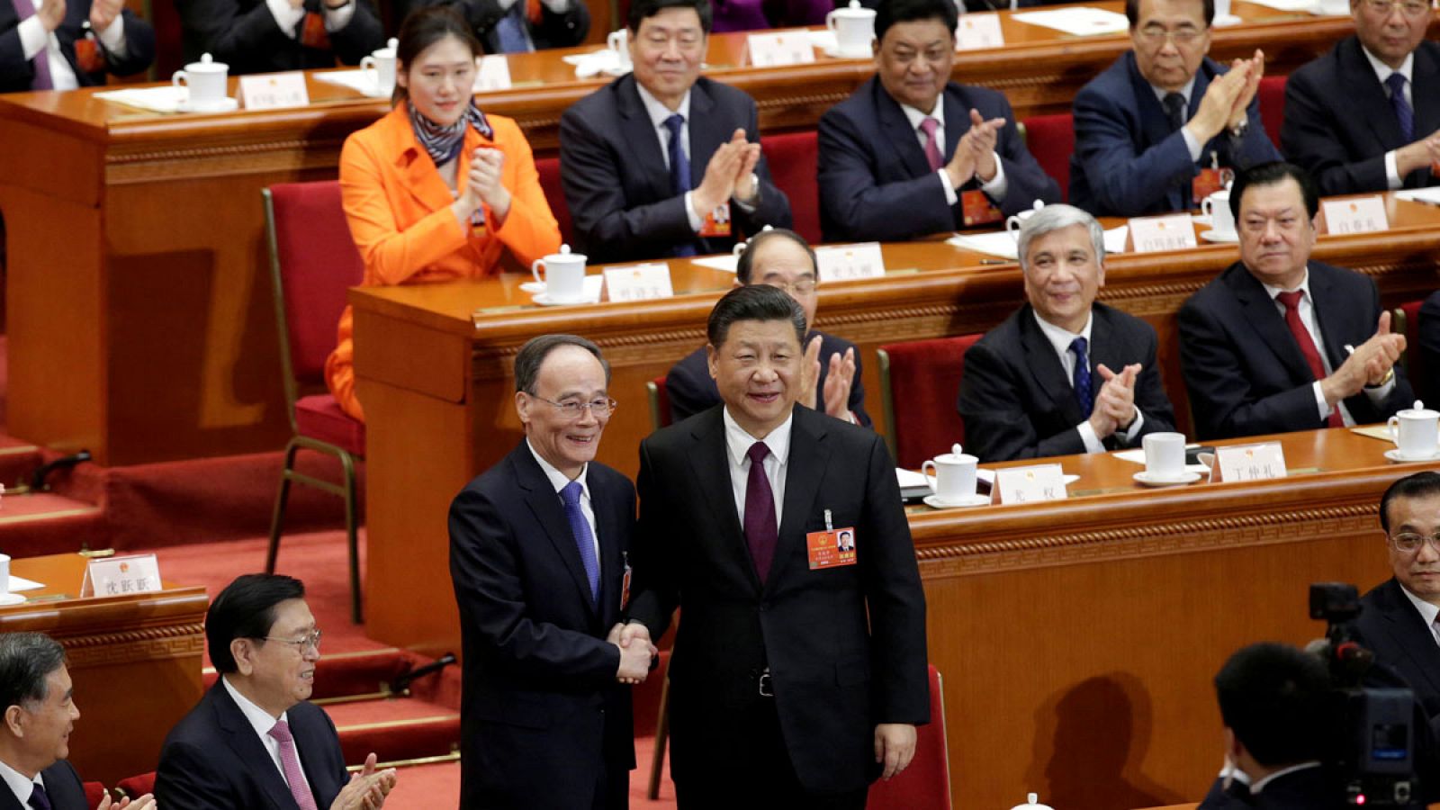 El presidente chino, Xi Jinping (d), estrechando la mano del nuevo vicepresidente Wang Qishan (i) en la quinta sesión plenaria de la Asamblea Popular Nacional (APN) en el Gran Palacio del Pueblo de Pekín el sábado 17 de marzo de 2018.