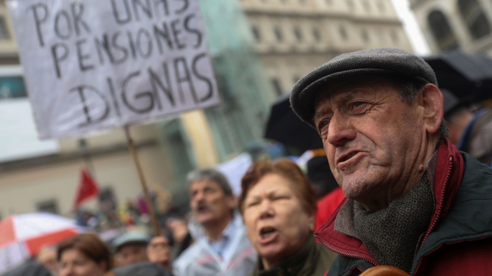 Un hombre grita durante la manifestación delante de un cartel que pide "pensiones dignas"