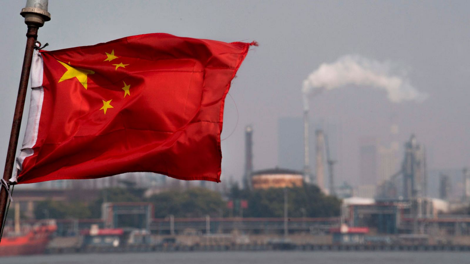 La bandera de China ondea en el puerto de Shanghai, frente a la refinería de la petrolera Gaoqiao