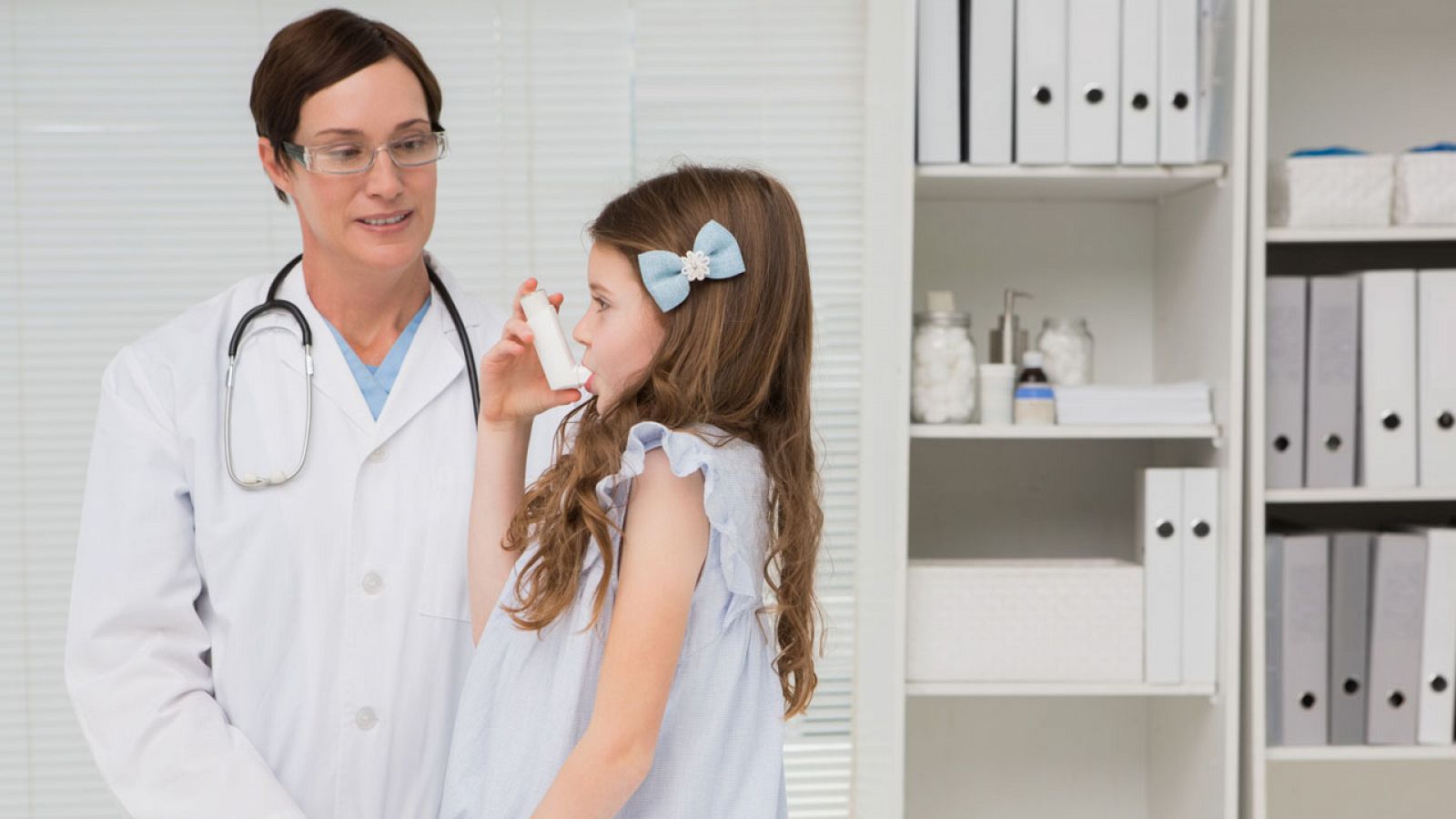 Una niña utiliza el inhalador en la consulta del médico