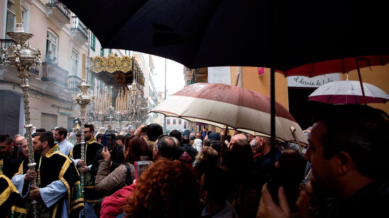 La gente ve bajo la lluvia una procesión de Semana Santa en Málaga el pasado Domingo de Ramos