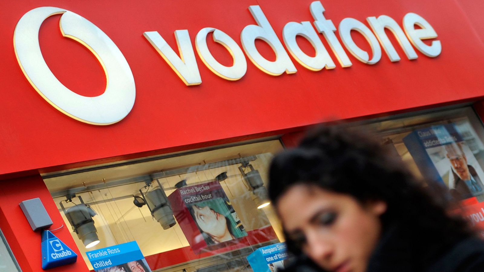 Una mujer pasa por delante de una tienda de Vodafone