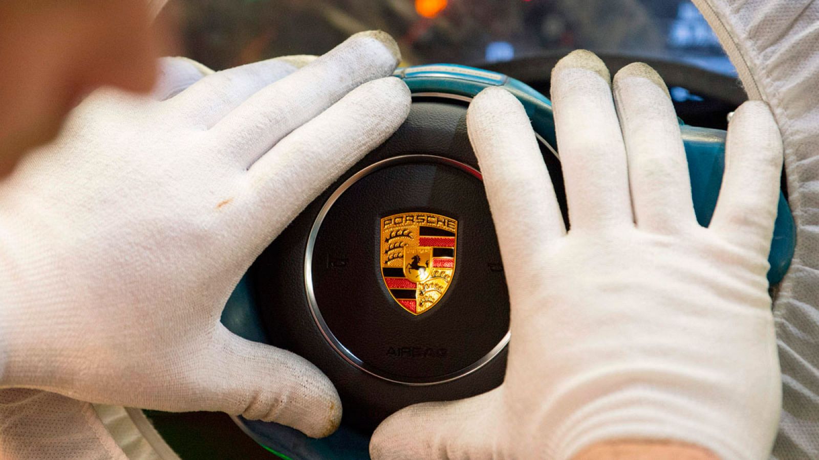 Un empleado coloca el embellecedor del volante de un Porsche en la fábrica de la marca en Stuttgart