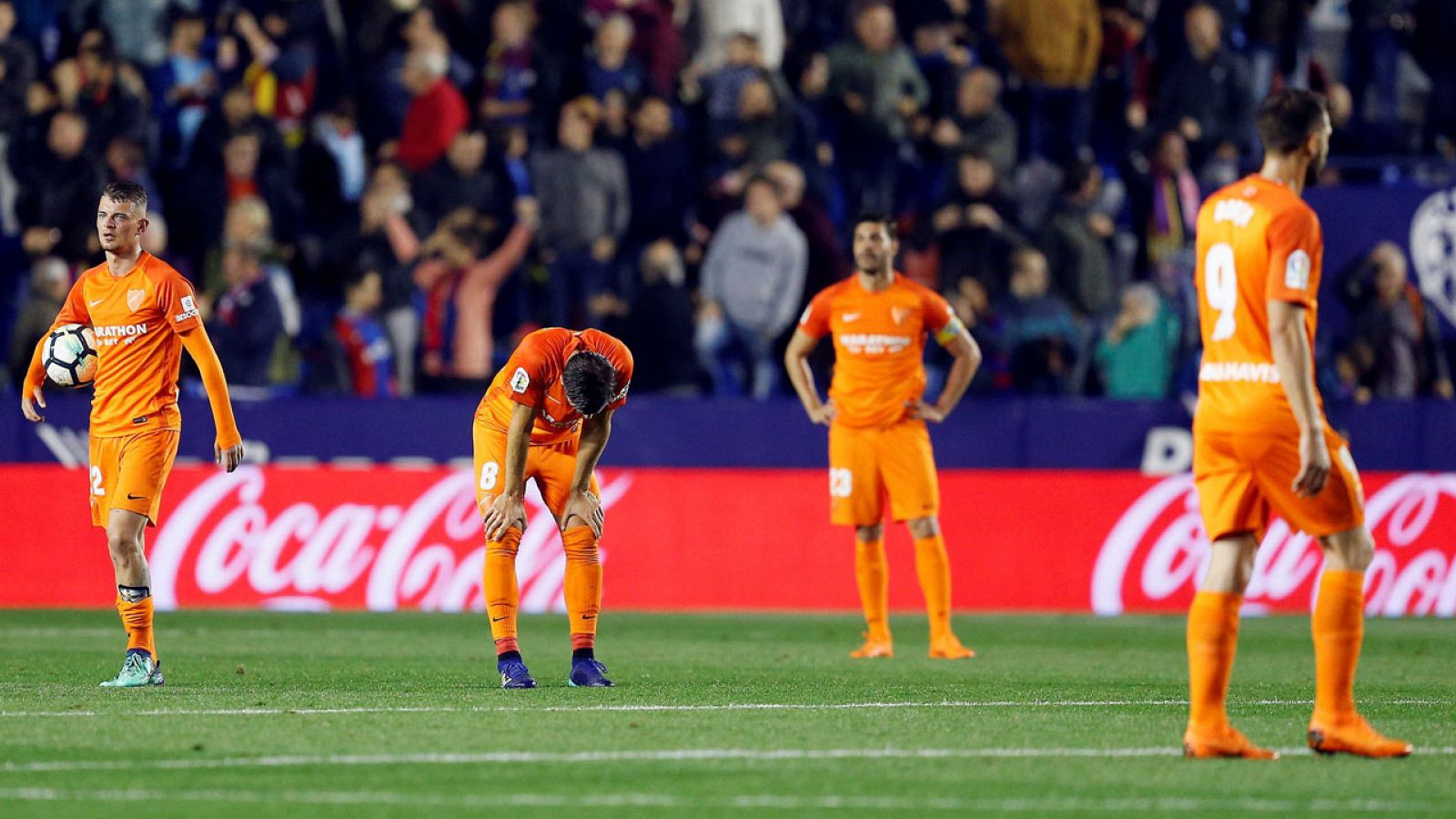 Los jugadores del Málaga, cabizbajos tras recibir el gol del Levante que supone su descenso a Segunda