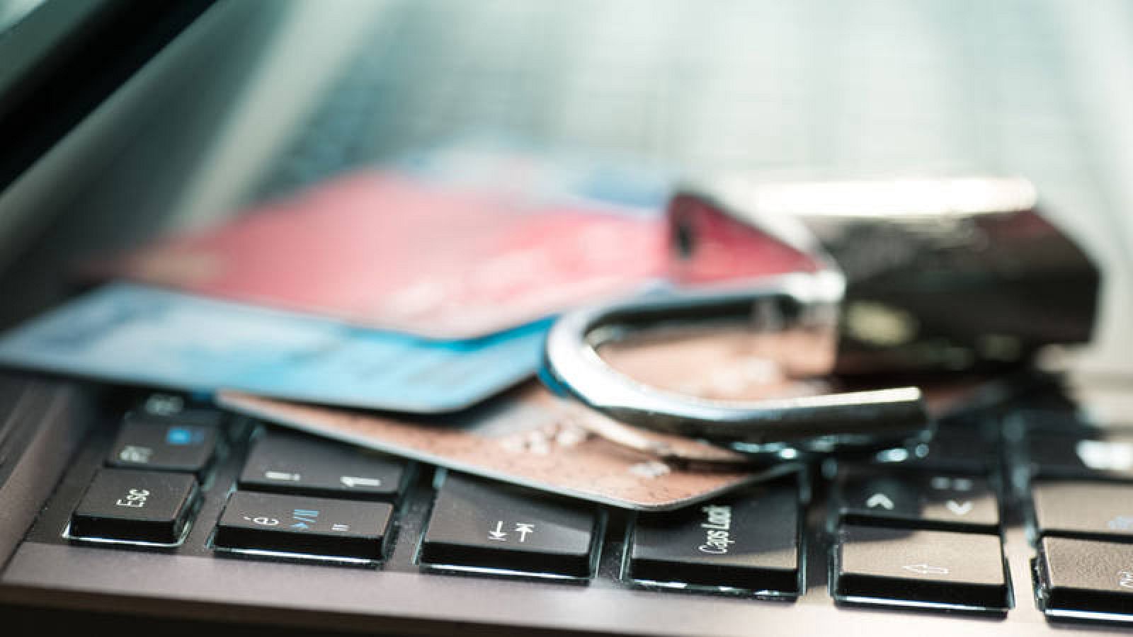 Tarjetas de crédito junto a un candado sobre un ordenador
