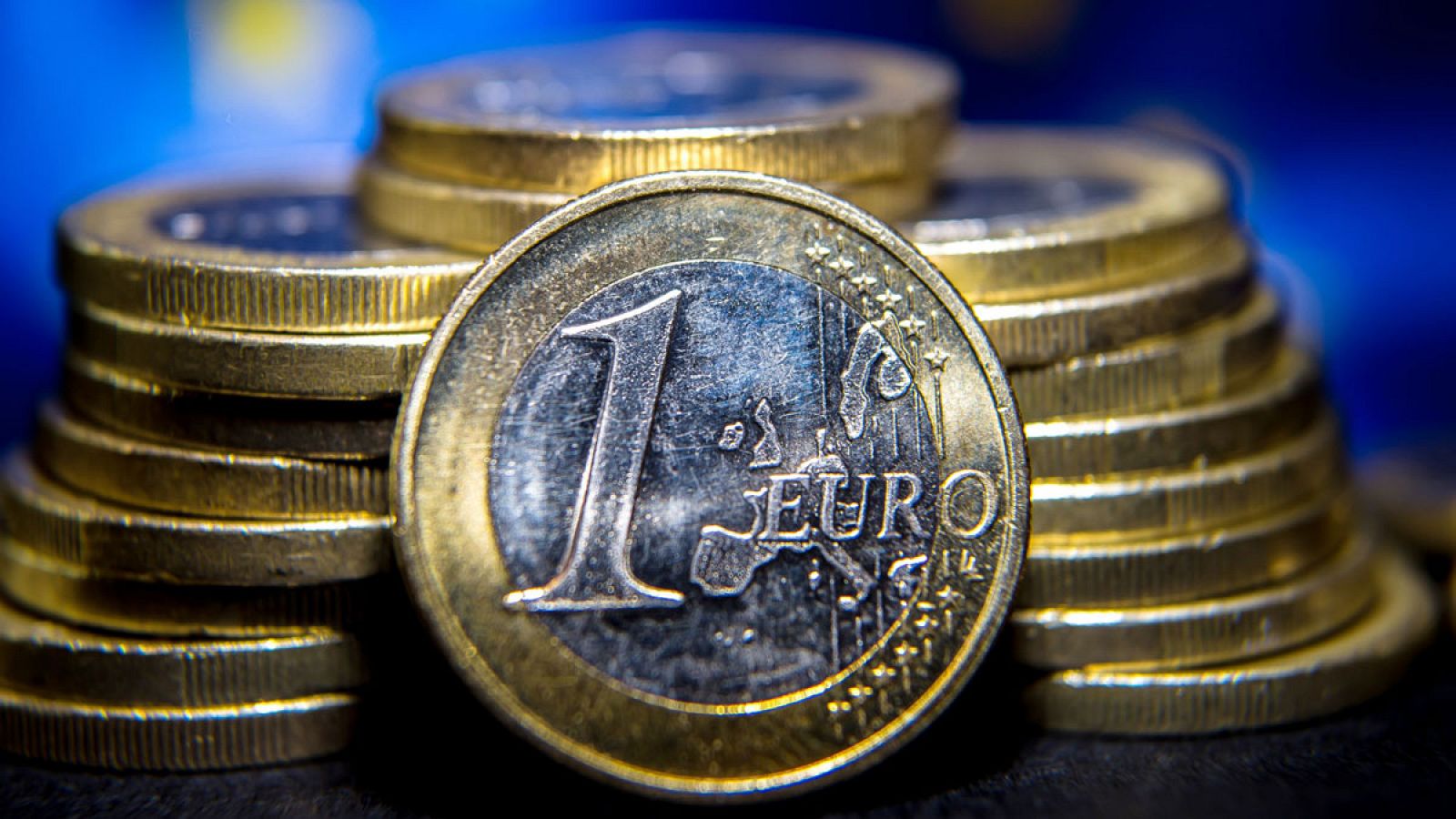 Un euro delante de varias torres de monedas