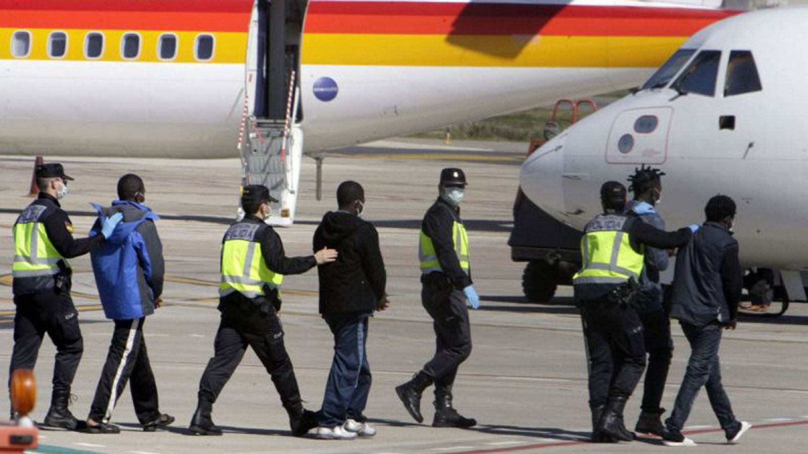 La Policía traslada hasta el avión a un grupo de inmigrantes que van a ser expulsados