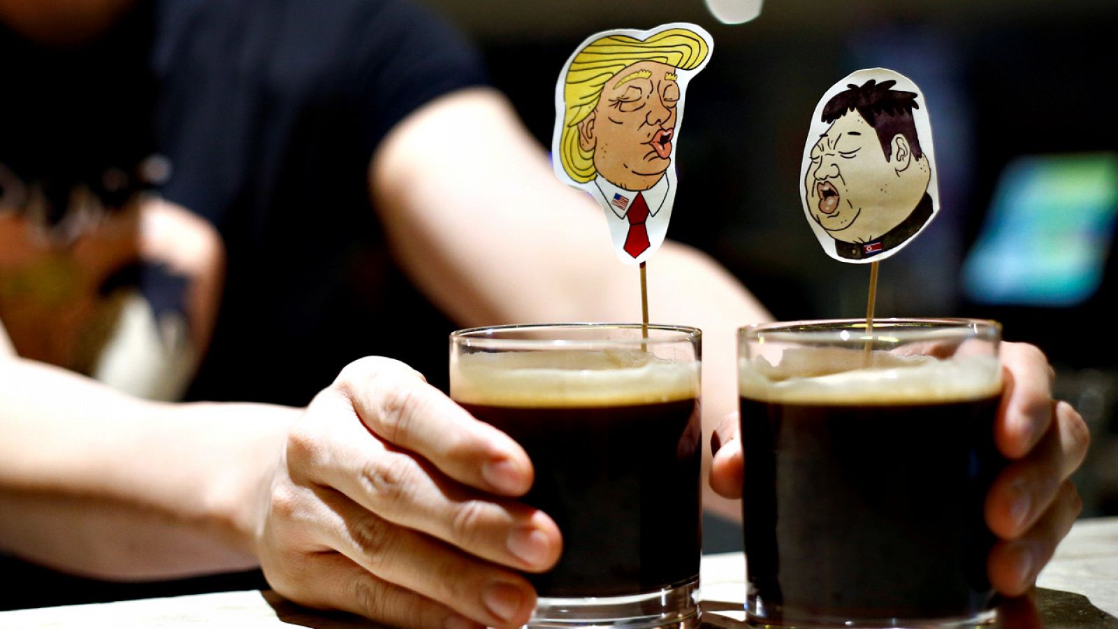 Un camarero presenta dos cócteles inspirados en Donald Trump y Kim Jong-un en un bar de Singapur