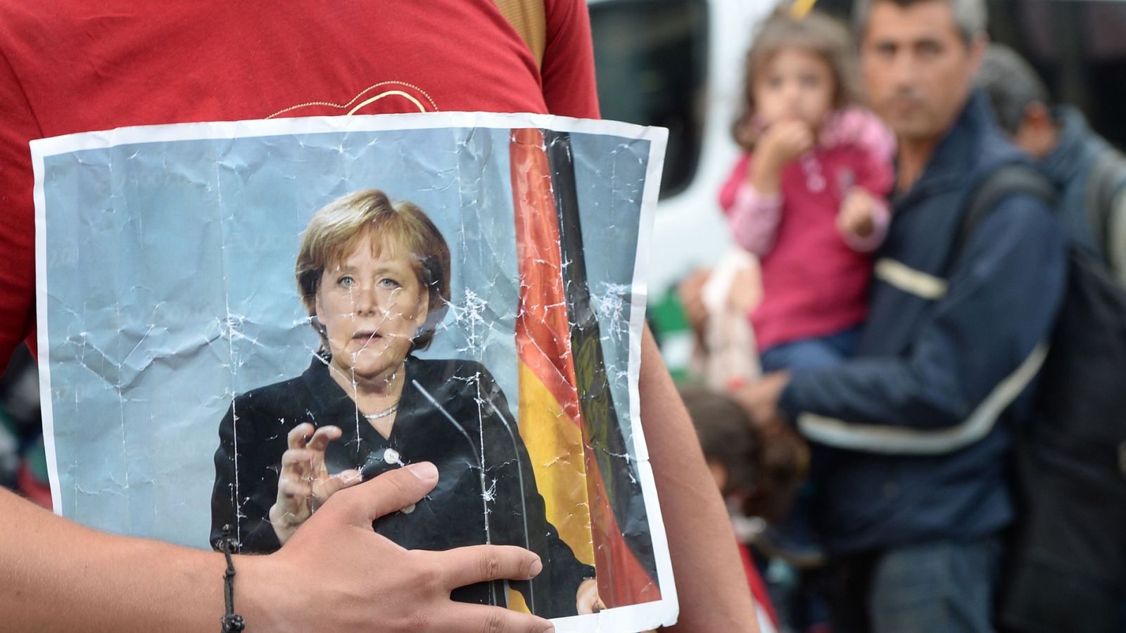 Un refugiado sostiene una foto de la canciller alemana Ángela Merkel en Munich, Alemania (foto archivo)
