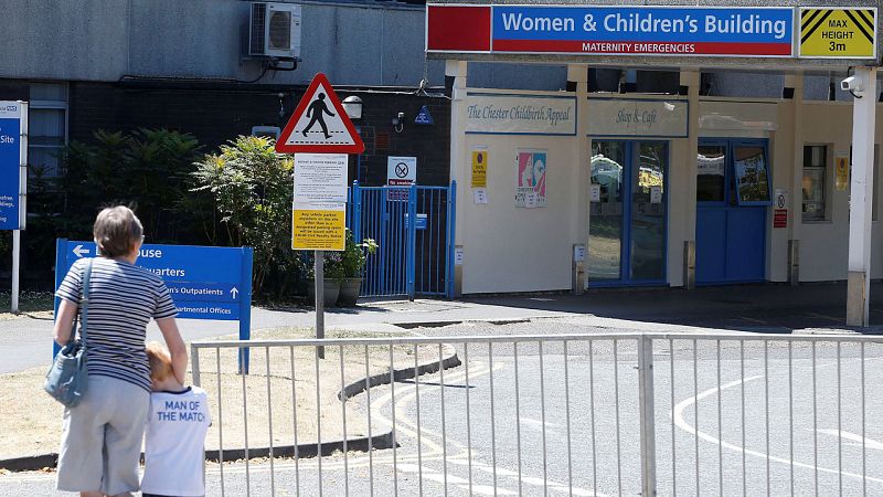 Una mujer pasea con un niño en la entrada del The Countess of Chester Hospital.