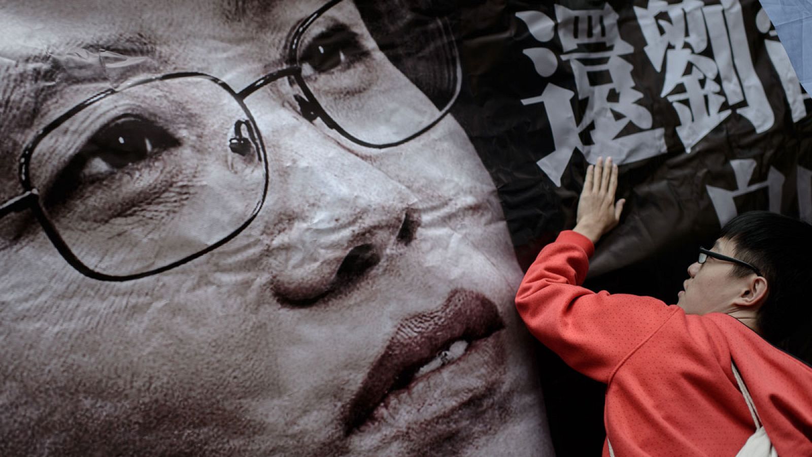 Un manifestante sujeta una fotografía gigante de Liu Xia durante una marcha de protesta en Hong Kong